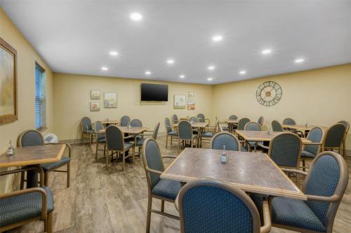 a dining room with tables and chairs and a tv at SureStay Plus Hotel by Best Western Elizabethtown Hershey in Elizabethtown