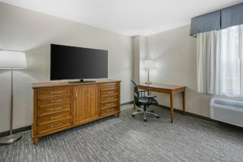 a hotel room with a tv and a desk with a chair at SureStay Plus Hotel by Best Western Elizabethtown Hershey in Elizabethtown