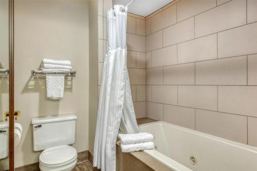 a bathroom with a white tub and a toilet at SureStay Plus Hotel by Best Western Elizabethtown Hershey in Elizabethtown