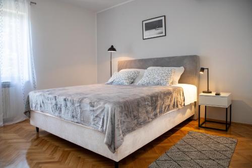 a white bedroom with a large bed and a window at Apartments with parking space Sveti Lovrec, Central Istria - Sredisnja Istra - 24888 in Medaki