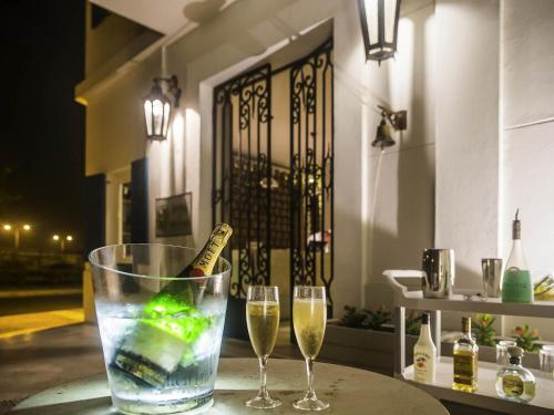 two glasses of wine and a bottle of champagne at Hotel Boutique Bovedas de Santa Clara By Accor in Cartagena de Indias