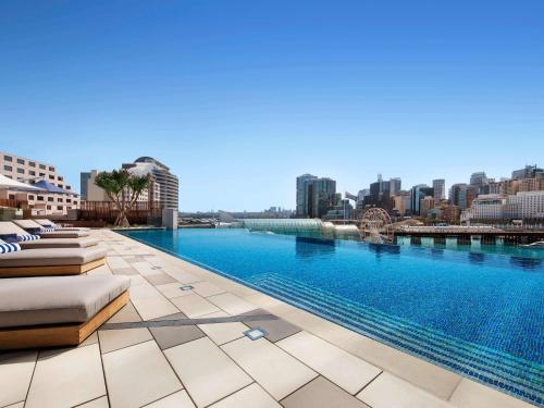 a swimming pool with a city skyline in the background at Sofitel Sydney Darling Harbour in Sydney