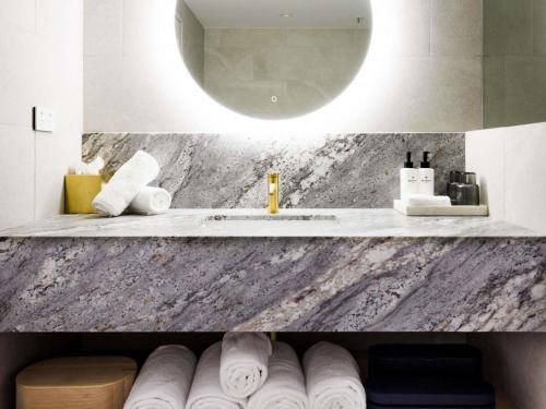 a bathroom with a sink and a counter with towels at Sofitel Noosa Pacific Resort in Noosa Heads
