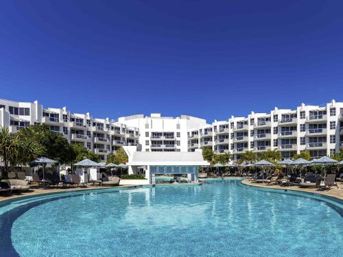 a large swimming pool in front of a large building at Sofitel Noosa Pacific Resort in Noosa Heads