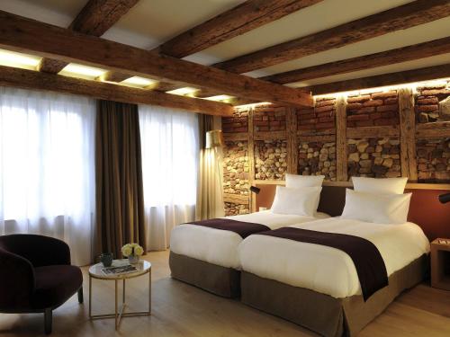 a hotel room with a large bed and a chair at 5 Terres Hotel & Spa - MGallery Collection in Barr