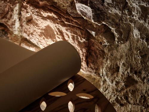 a room with a stone wall and a circular ceiling at 5 Terres Hotel & Spa - MGallery Collection in Barr