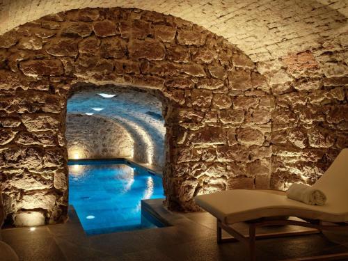 a room with a pool of water in a stone wall at 5 Terres Hotel & Spa - MGallery Collection in Barr