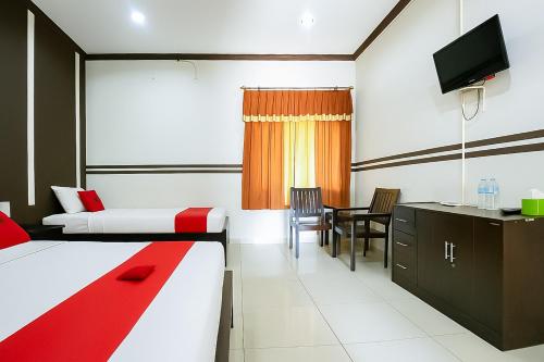 a hotel room with a bed and a dining room at RedDoorz at Hotel Mutiara Kuningan in Sangkanurip
