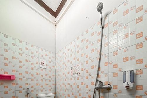 a bathroom with a shower and a toilet at RedDoorz at Hotel Mutiara Kuningan in Sangkanurip