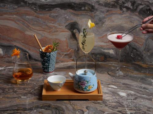 a table with two cocktails and two glasses and a drink at Sofitel Singapore City Centre in Singapore