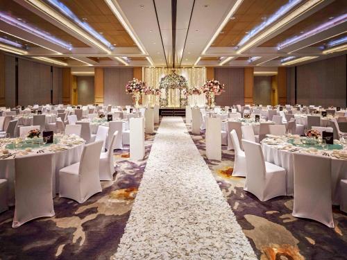a banquet hall with white tables and white chairs at Sofitel Singapore City Centre in Singapore