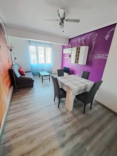 ein Esszimmer mit einem Tisch und einer lila Wand in der Unterkunft céntrico, tranquilo, garaje, colchones visco, ascensor, luminoso y wifi in Logroño