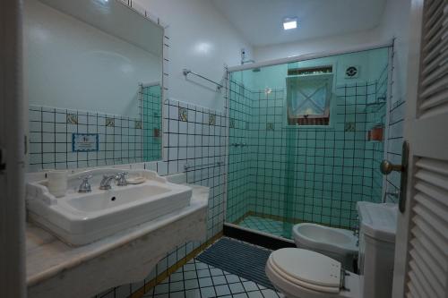 a bathroom with a sink and a toilet and a shower at Casa da Ilha & SPA in Abraão