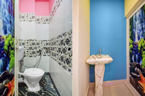 a bathroom with a toilet and a sink at Hotel O Gypsy and Restaurant in Khalsini
