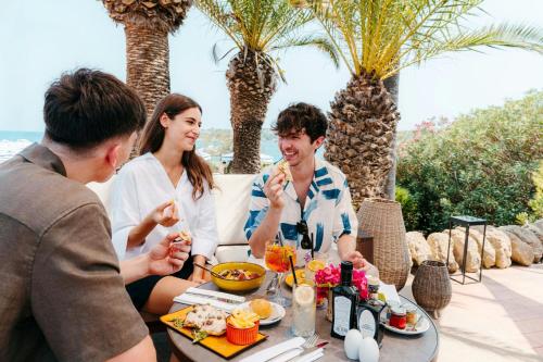a group of people sitting around a table eating food at Mangia's Brucoli, Sicily, Autograph Collection in Brucoli