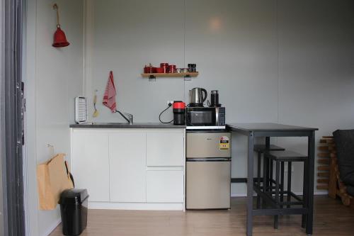 a kitchen with a counter with a microwave and a table at Night Sky Magic in Olive Grove in Gladstone