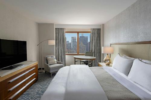 a hotel room with a large bed and a television at The Westin New York at Times Square in New York