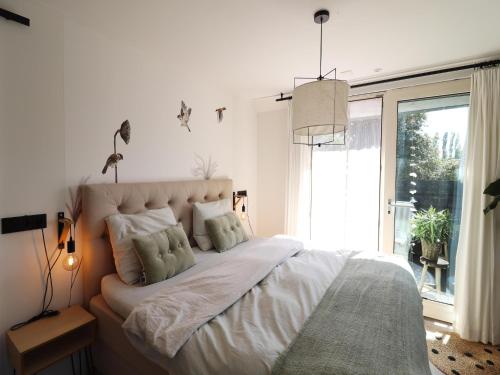 a bedroom with a large bed with a large window at Beautifully styled apartment in Engelum