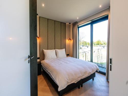 ein Schlafzimmer mit einem Bett und einem großen Fenster in der Unterkunft Stay with Private Pool & Hot Tub in Waarland