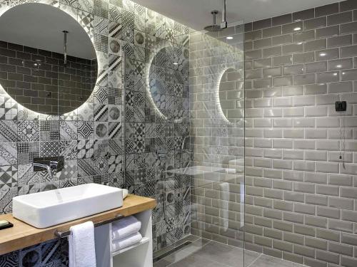 a bathroom with a sink and a shower at Tarcin Forest Resort & Spa Sarajevo - MGallery Collection in Tarčin