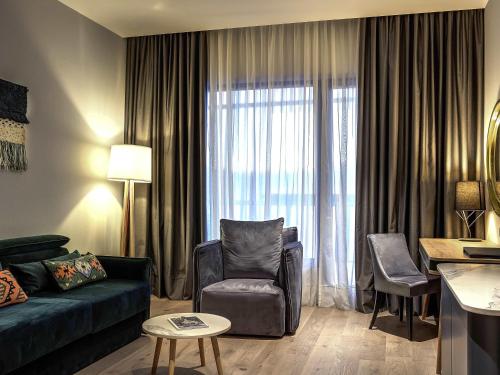 a living room with a couch and a chair at Tarcin Forest Resort & Spa Sarajevo - MGallery Collection in Tarčin