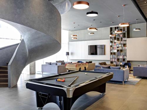 a living room with a pool table and couches at Tarcin Forest Resort & Spa Sarajevo - MGallery Collection in Tarčin