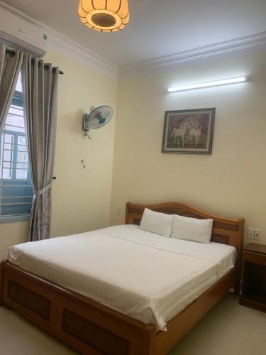 a bedroom with a bed in a room with a window at Areca Homestay in Hoi An