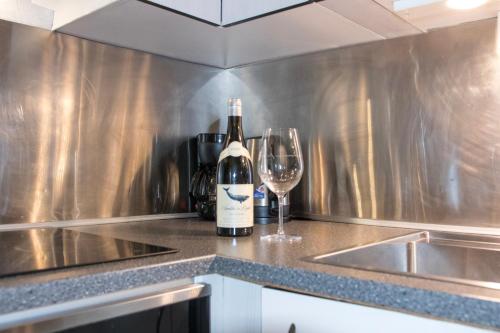 a bottle of wine and a glass on a kitchen counter at Arctic Apartment Heart of Tromsø in Tromsø