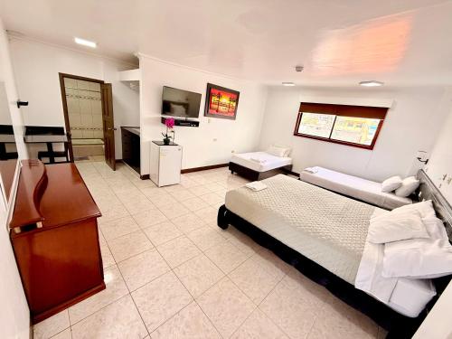 a large bedroom with a bed and a living room at Hotel Los Algarrobos in Puerto Baquerizo Moreno