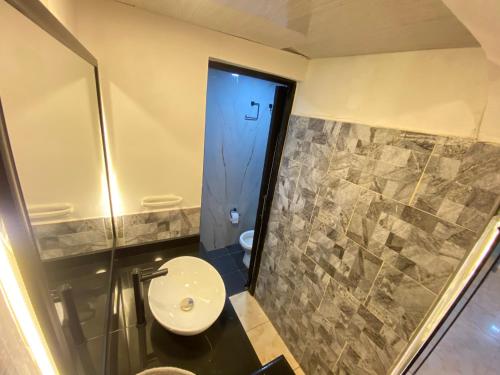 a bathroom with a toilet and a shower and a sink at Le”More House in Girardot