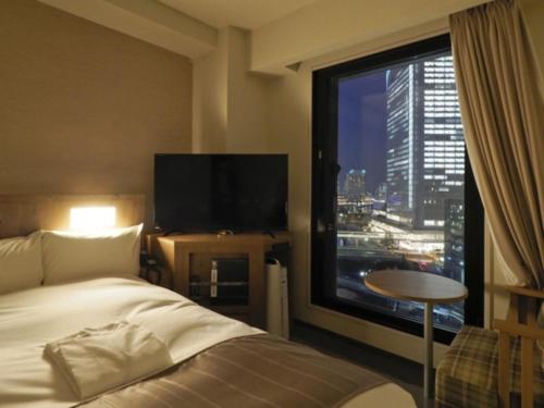 a hotel room with a bed and a large window at Far East Village Hotel Yokohama - Vacation STAY 35243v in Yokohama