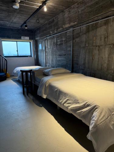 a room with three beds and a wooden wall at RePORTHOTEL in Yaizu