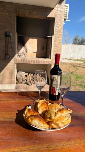 a plate of food with a bottle of wine and glasses at Terroir Village - Complejo en Mendoza in Guaymallen