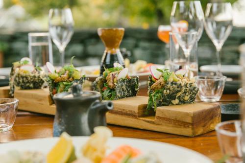 a table with plates of food and glasses of wine at Millbrook Resort in Arrowtown