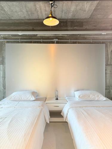 two beds sitting next to each other in a bedroom at RePORTHOTEL in Yaizu