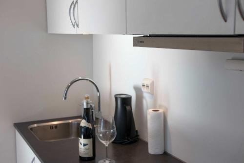 - un comptoir de cuisine avec évier et une bouteille de vin dans l'établissement Arctic View 2-Bedroom Apartment, à Tromsø