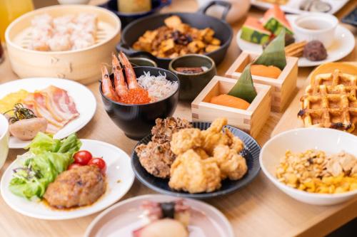a wooden table with plates of food on it at ホテルエノエ富山 in Toyama