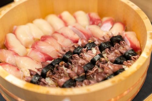 a wooden bowl filled with fruit and berries at ホテルエノエ富山 in Toyama