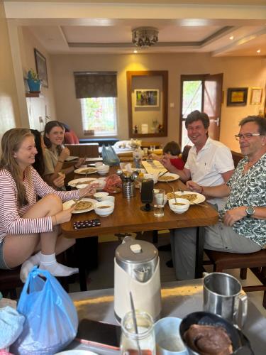 a group of people sitting at a table eating food at Mums Homestay & Studio Apartments in Kathmandu