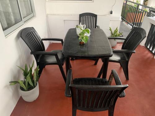 una mesa negra y sillas con una planta en Double G Motel, en Weligama