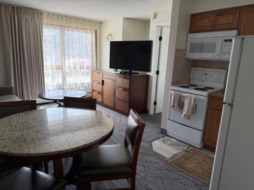 a kitchen with a table and a kitchen with a stove and refrigerator at Snowshoe Motel in Frisco