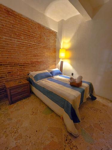 a bedroom with a large bed with a brick wall at Habitaciones Casa Bule in Oaxaca City
