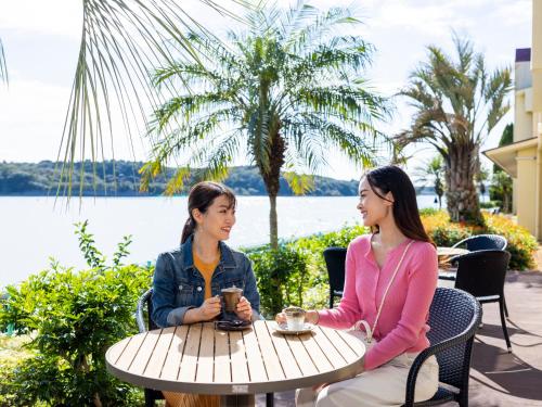 two women sitting at a table in front of a lake at Haifu in Shima