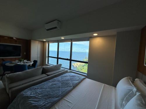 a bedroom with a bed and a view of the ocean at Tropical executive vista Rio in Manaus