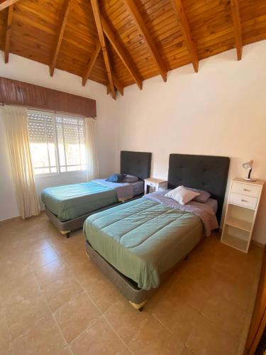 a bedroom with two beds in a room with a wooden ceiling at Duplex 3 - Calle 15 in San Clemente del Tuyú