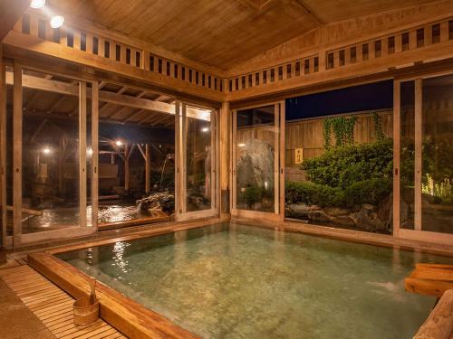 a swimming pool in a house with a large window at Haifu in Shima