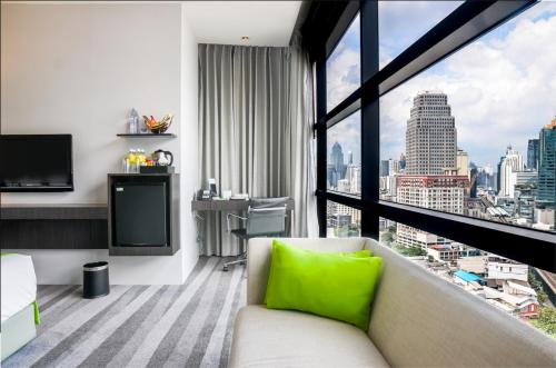a living room with a couch and a large window at Holiday Inn Bangkok Sukhumvit by IHG in Bangkok