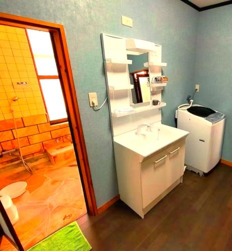 a bathroom with a sink and a mirror at COCO 湯布院 一棟貸切 ーCOCO Yufuinー in Yufu