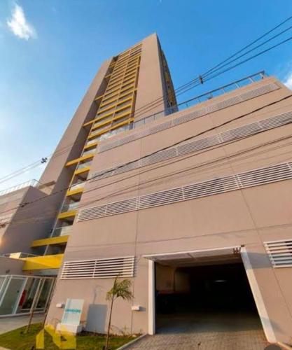 a large building with a parking garage in front of it at Studio Mogi das Cruzes in Mogi das Cruzes