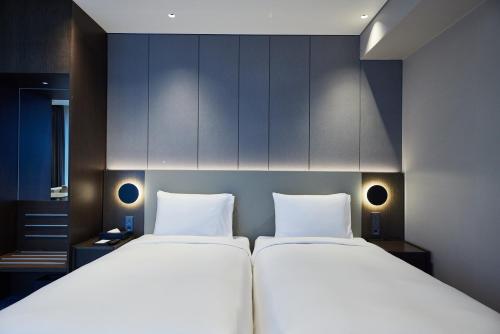 two large beds in a room with blue cabinets at Hotel HLB in Busan